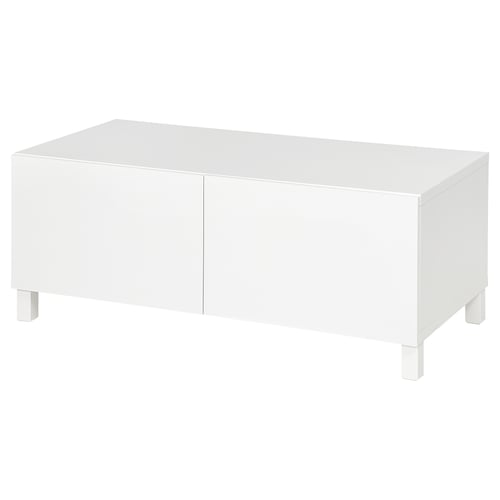White BESTÅ coffee table with hidden storage compartments and adjustable feet for stability.