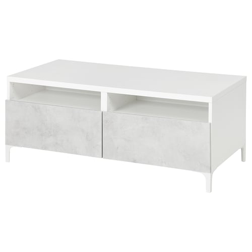 White BESTÅ coffee table with open shelves and drawers, on slim metal legs.