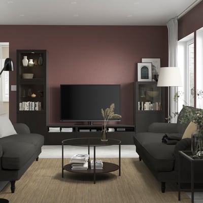 Modern living room with flat screen tv, BESTÅ shelves, dark sofas, and rug.