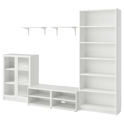 A white BILLY modular storage set, including a tv bench, wall shelves, cabinet, and bookcase, with glass doors and open compartments.