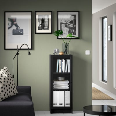 Modern living room with BILLY black bookshelf, black couch, and window.