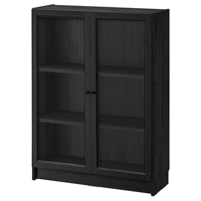 A black BILLY bookcase with glass doors. The rectangular shape has adjustable shelves and sturdy design with modern appeal.