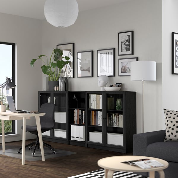 Contemporary living room with BILLY bookcase, couch, desk, lamp, plant, & art.