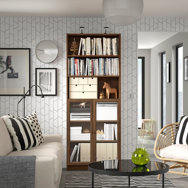 Modern living room with BILLY bookshelf, decor, clock, pillows, rug, and wood furniture.