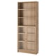A BILLY light brown bookcase with glass doors. It has five shelves, three open and two behind glass.