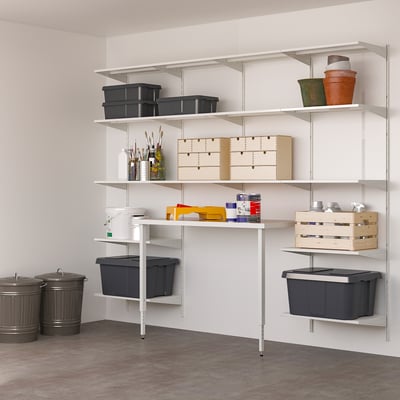 BOAXEL white wall storage system organised with black bins, wooden crates, and small items. Large, efficient, and adaptable for various uses.
