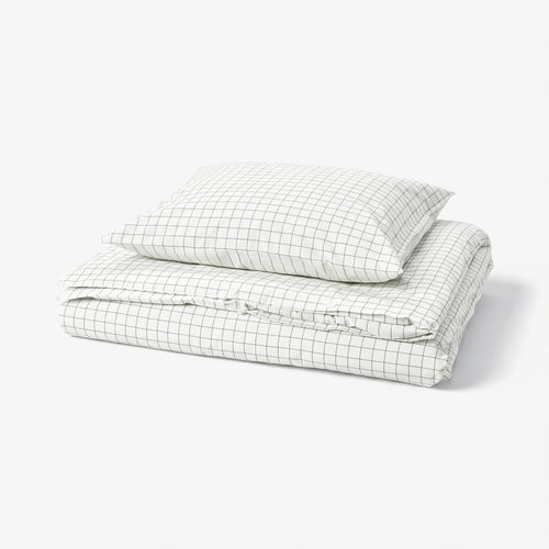 Folded white grid-patterned cotton DOFTAKLEJA duvet and pillow set on white background.