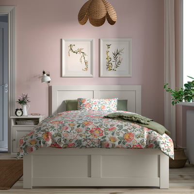 FÅGELFJÄLLET bed in white with floral bedding, pink walls, art, and pendant.