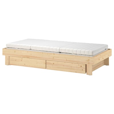 Natural wood extendable bed with white mattress, ideal for space-saving and versatile use.