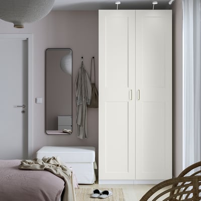 Modern bedroom with large white GRIMO wardrobe, minimalist decor, and neutral bed.