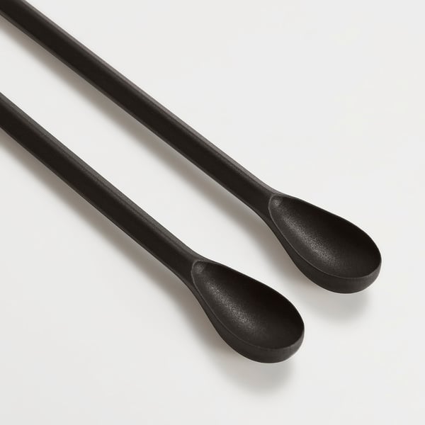Two sleek black kitchen utensils with silicone tips and long handles displayed on a white surface.