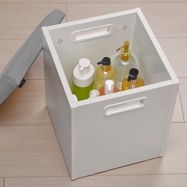 White storage box with bottles, wooden floor.