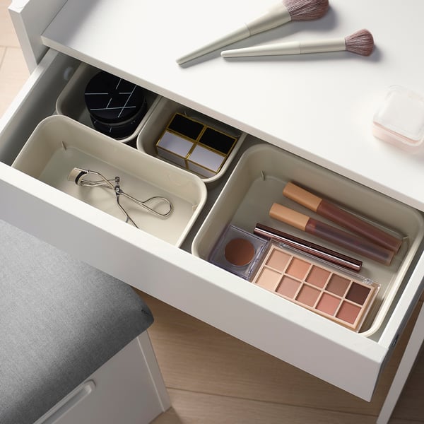 Open vanity drawer with compartments for makeup brushes, palettes, and tools.