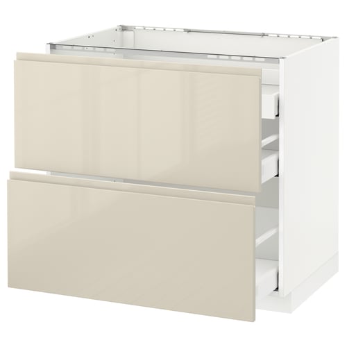 A white METOD kitchen cabinet with two high-gloss beige drawers. The cabinet has a modern, minimalist design with integrated handles.
