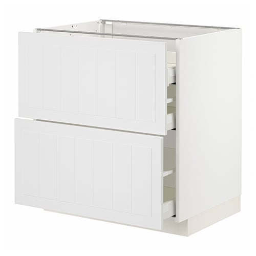 White METOD kitchen cabinet with vertical grooves and opened drawers, made of particleboard and steel.