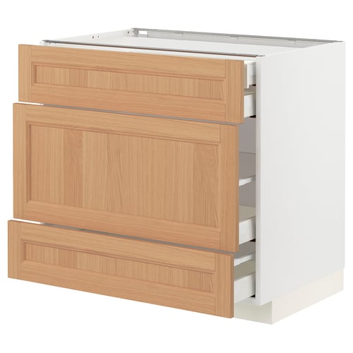A white METOD kitchen cabinet with oak drawers, three partially open, showing organised compartments.