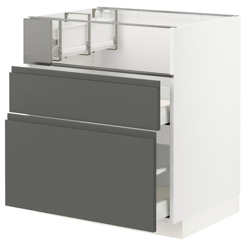 A modern kitchen cabinet in white with dark grey drawers. It integrated handles and a sleek design.
