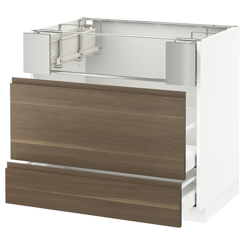 An empty kitchen cabinet frame with walnut drawer fronts. It is white and has a modern design.