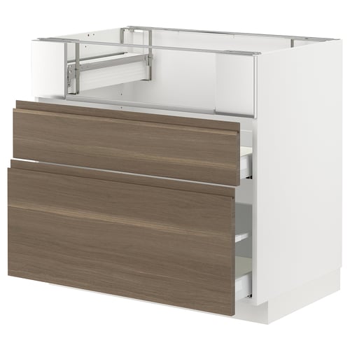 Modern white kitchen unit with dark walnut drawers, integrated handles.
