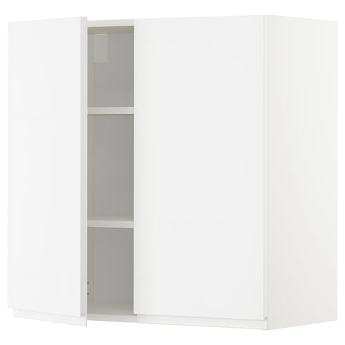 A white METOD kitchen cabinet with two doors, one open, revealing an adjustable shelf inside. Modern, minimalist design.