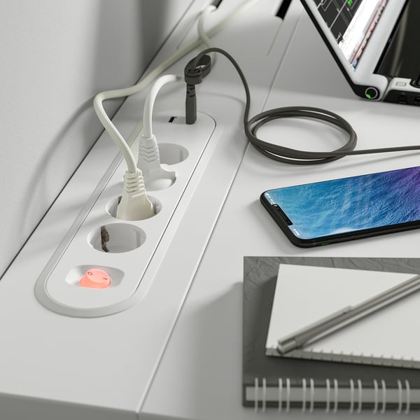 Desk with built-in power outlets and usb ports, charging multiple devices efficiently.