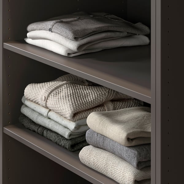 Shelf with several neatly folded towels in varying shades of grey and white, showcasing organised storage.