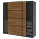 An IKEA PAX wardrobe with wooden doors and black sides. It sliding doors and multiple drawers for storage.