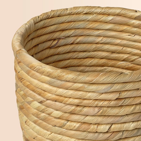 Wicker basket with tightly woven coils, natural beige colour, round shape.