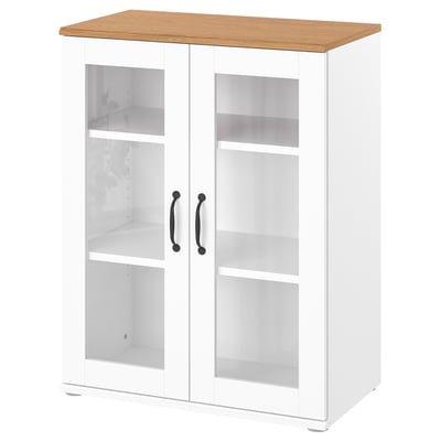 A white SKRUVBY storage cabinet. The top is light wood. It has glass doors with metal handles, displaying empty shelves inside.