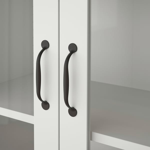 Close-up of two sleek, modern handles on a clean, white cabinet. Curved design, matte finish, attached firmly to smooth surface.