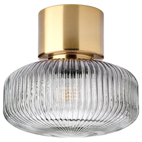 Elegant brass ceiling lamp with ribbed glass shade, casting soft light.