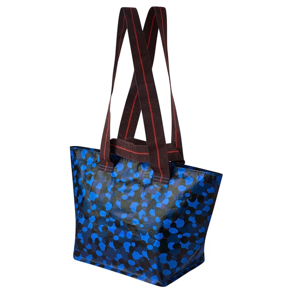 Blue dotted reusable tote bag with brown straps against white background.