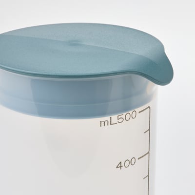 A clear plastic container with teal lid, marked with measurement lines, used for mixing and storing shakes or batters.