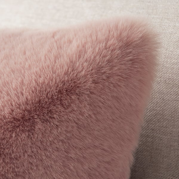 Soft pink, plush fabric close-up, smooth and inviting texture, likely from a cushion cover.
