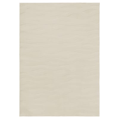 Displays a VÄXELFEL rug in beige, featuring a soft, wavy 3d pattern and recycled polyester material.