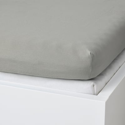 A light grey fitted bed sheet made of cotton, designed to fit mattresses up to 16 cm thick, displayed on a white surface.