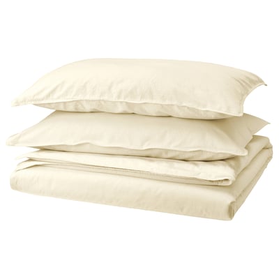 Folded ivory-colored bedding set including flat sheet, fitted sheet, and pillowcases, made of soft pre-washed cotton with envelope closure design.