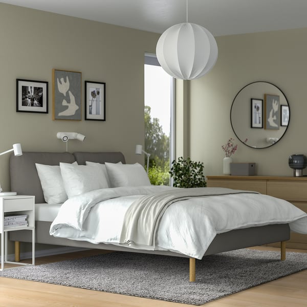 Modern bedroom with grey ÄRENDE rug, matching bed, and white pendant light. Minimalist decor.
