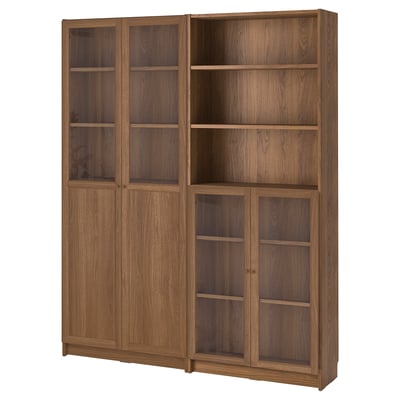A BILLY wooden bookcase with glass doors. Its brown, has adjustable shelves, and a sturdy design.