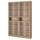 A BILLY bookcase in oak veneer with glass doors. It has multiple shelves and a traditional design.