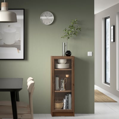 Modern dining room with BILLY bookshelf, clock, and hanging light.