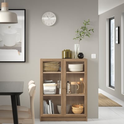 Modern living room with wooden BILLY bookcase, grey walls, chair, and decor.