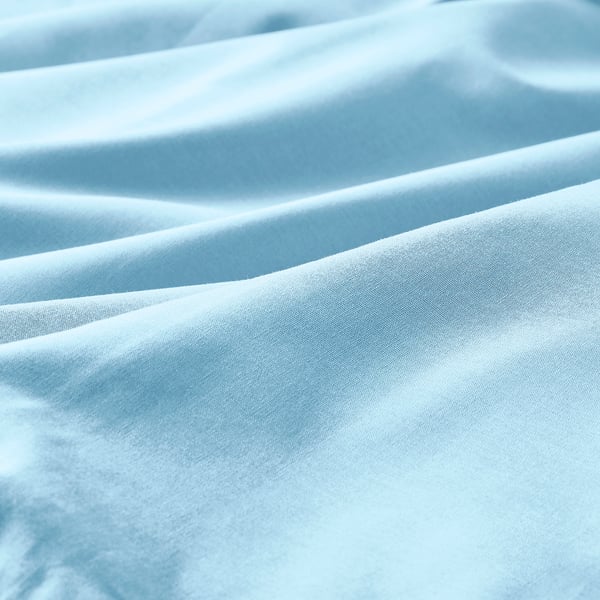 Light blue cotton fabric folds, showcasing smooth texture and soft creases.