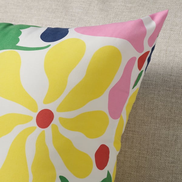 Bright throw pillow with abstract floral design in yellow, pink, green, and blue on white background. Soft and colourful, adding vibrancy and comfort.