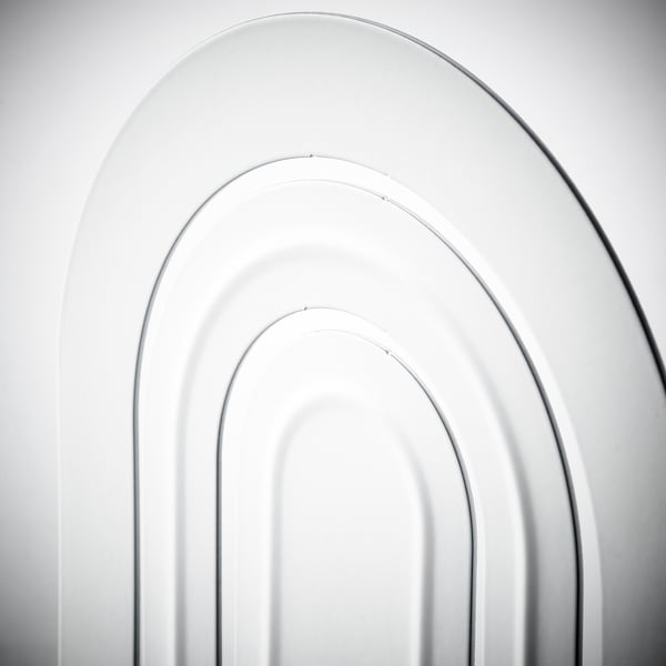 Modern white bookend with three arched slots, made of sturdy epoxy-coated steel.