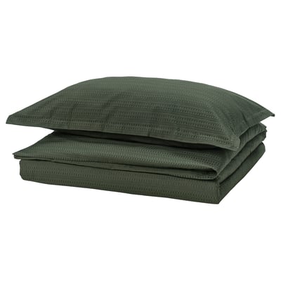 Dark green folded bedding set with waffle texture, neatly stacked, in soft cotton material.