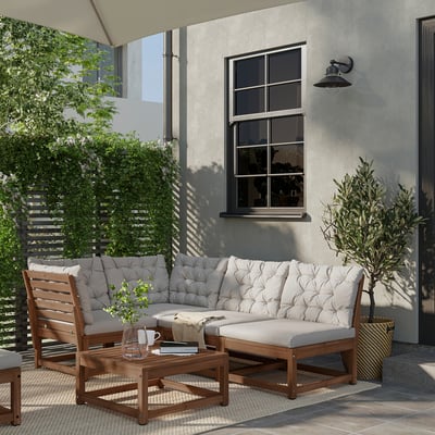 Comfortable outdoor living area with beige NÄMMARÖ sectional sofa, wooden table, and plants.