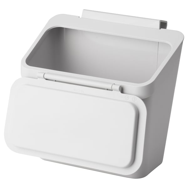A white IKEA skolaest hanging waste bin with a square shape and lid. Made of polypropylene plastic, it hangs over doors for easy waste disposal.