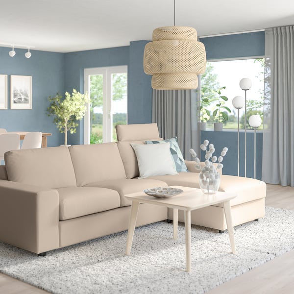 Modern living room with beige VIMLE sofa, blue walls, pendant lamp, coffee table, large windows, and plants.
