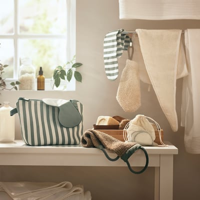 Bathroom counter with striped bag, knit pouches, towels, and bottles.